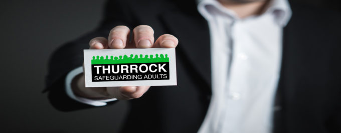 Image of someone holding the Thurrock Safeguarding Adults Board logo